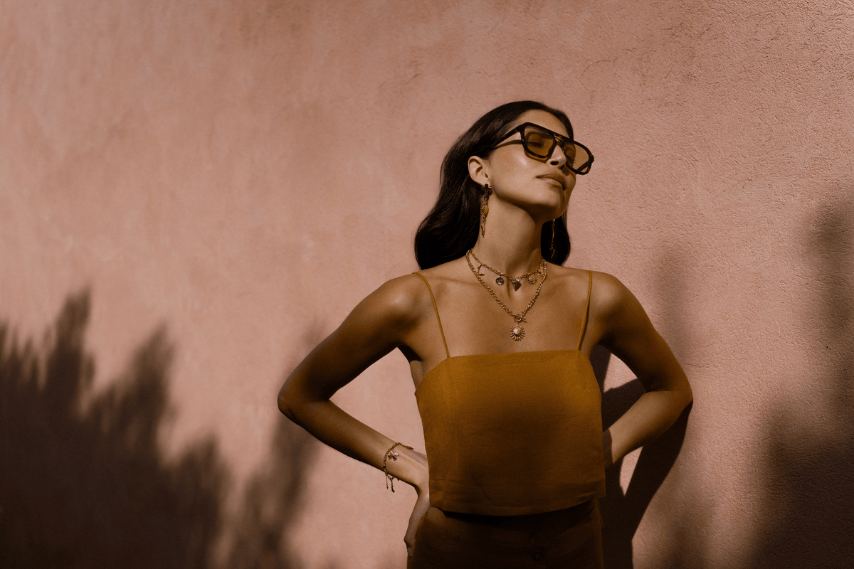 Model wearing Orelia Statement jewellery pieces, necklaces and earrings in gold. 