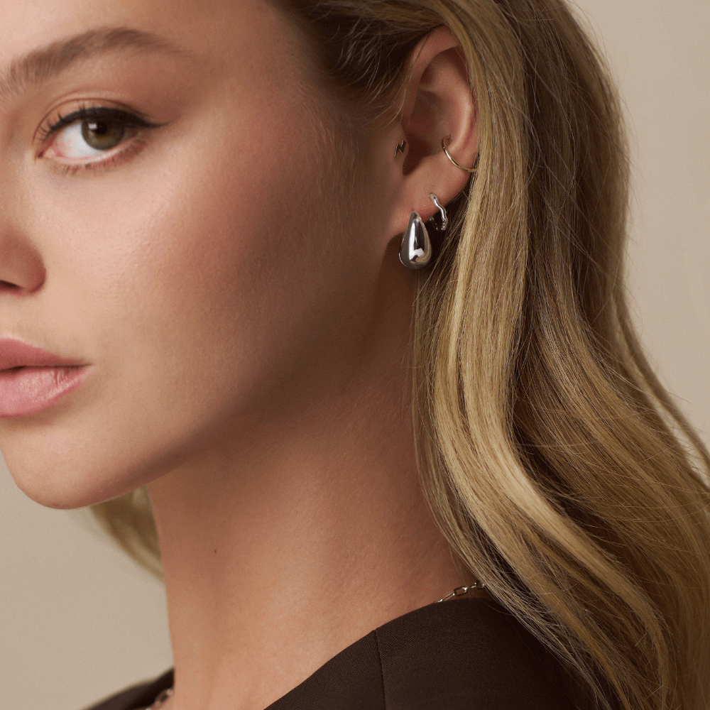 Model Wearing Earrings Organic Round Wave Huggie Hoops Silver